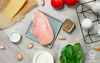 Подготовьте продукты для салата «Нежность». Курицу при необходимости разморозьте. Сыр натрите на средней терке. Чеснок почистите. Листья салата помойте, обсушите от лишней влаги. Помидоры ополосните, нарежьте кубиками.