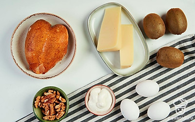 Достаньте все продукты. Киви помойте и очистите от кожицы. Яйца сварите вкрутую, остудите и почистите. Достаньте несколько мисок, терку и сервировочную тарелку.