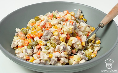 Сделайте салат. В салатнике смешайте курицу, яйца, морковь, говядину, картофель, лук, огурцы, зеленый горошек и кукурузу. Добавьте майонез, перец и соль. Хорошо все размешайте.