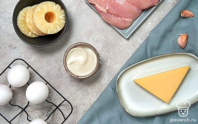 Отварите куриное филе и яйца в подсоленной воде. Остудите. Яйца и грецкий орех очистите от скорлупы. Промойте чеснок, очистите. Удобно разложите на столе необходимые продукты.