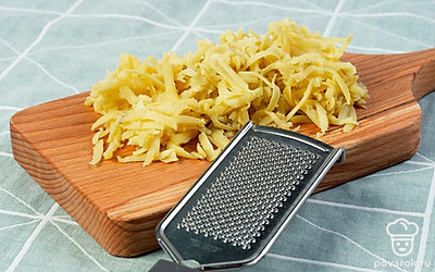 Сварите картофель. В отдельную кастрюлю сложите неочищенные клубни картофеля. Залейте их водой и поставьте на сильный огонь. Доведите воду до кипения и варите, уменьшив огонь, примерно 25-30 минут. После варки клубни остудите, очистите от кожуры и натрите на крупной терке.