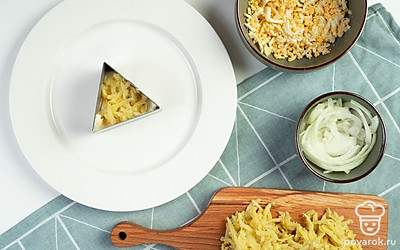 Приступите к формированию слоеного салата. На большую тарелку первым слоем выложите курицу, затем слой майонеза. Далее разложите маринованный лук. Следующим слоем посыпьте отварной картофель. Сверху распределите майонез и измельченные яйца. На них натрите плавленый сыр.