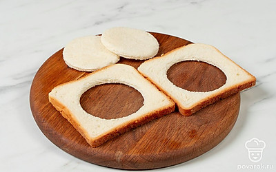 Возьмите хлеб и в центре каждого ломтика вырежьте круг.