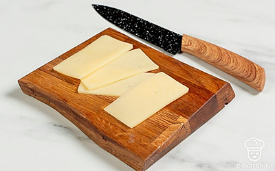 Нарежьте сыр тонкими ломтиками.