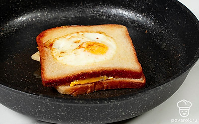 Когда сыр слегка расплавится, соедините ломтики хлеба друг с другом так, чтобы он оказался внутри. Подержите закуску на огне еще 2 минуты до готовности.