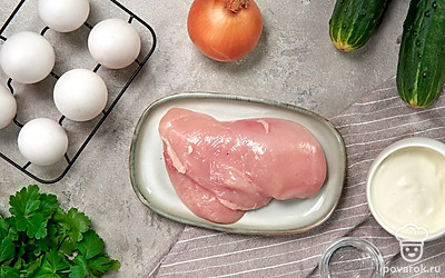 Куриное филе тщательно промойте, при необходимости очистите от пленки и жилок, после чего отварите в подсоленной воде в течение 20 минут до полной готовности. Репчатый лук очистите, сполосните и нарежьте мелкими кубиками. После этого поместите их в отдельную емкость, залейте кипятком и оставьте на 10 минут. Далее смените воду на холодную, добавьте уксус и оставьте лук еще на 5 минут. Огурцы и петрушку хорошо вымойте, просушите. Также возьмите сковороду.