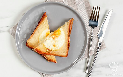 Выложите сэндвич с сыром и яйцом на тарелку. Разрежьте его пополам по диагонали, чтобы получилось два треугольника. Подайте горячие тосты на завтрак.