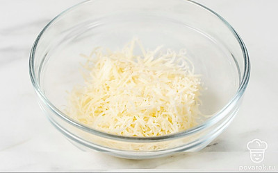 Измельчите сыр на мелкой терке и переложите его в глубокую миску.