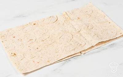 Выложите лист лаваша на рабочую поверхность. Сверху положите еще один лист.