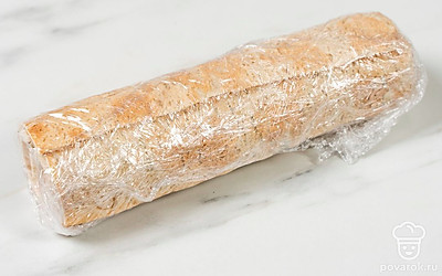 Аккуратно сверните лаваш в плотный рулет. Оберните его пищевой пленкой и уберите в холодильник на 15-20 минут.