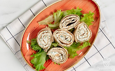 Нарежьте рулет на одинаковые ломтики. Перед подачей застелите тарелку листьями салата, а сверху выложите закуску. 