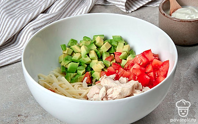 Приготовьте салат. Смешайте в салатнице авокадо, курицу, сыр и помидор, добавьте йогурт, немного посолите и хорошо перемешайте.