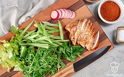 Завершите приготовление салата. Порвите листья салата на несколько частей. Редис порежьте кружочками, сельдерей — дольками. Сделайте заправку. Возьмите пиалу и смешайте лимонный сок, оливковое масло. Добавьте соль и перец по вкусу, перемешайте. Достаньте большую тарелку. Сначала налейте немного кисло-сладкого соуса, затем положите листья салата на тарелку. Добавьте к ним сельдерей и редис, полейте небольшим количеством заправки. Сверху положите курицу и полейте ее оставшимся соусом.