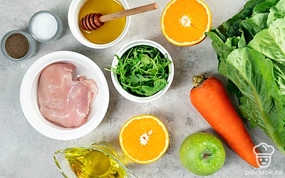 Куриное филе разморозьте, помойте и отварите в течение 15 минут в подсоленной воде. Остудите и слейте воду. Апельсин и яблоко промойте. Очистите от кожуры апельсин и вырежьте сердцевину у яблока. Морковь промойте и очистите от кожуры. Листья салата и руколу промойте и обсушите бумажным полотенцем.