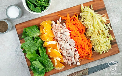 Нарежьте ингредиенты для салата. Куриное филе нарежьте тонким полосками. Зеленое яблоко и половину моркови натрите на крупной терке. Апельсин нарежьте на круглые дольки, затем на четвертинки. Листья салата и руколу нарвите крупными кусочками.