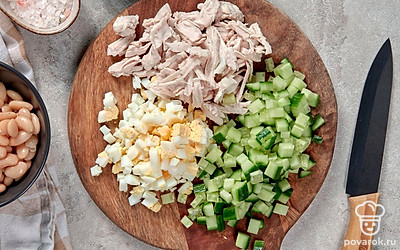 Приготовьте ингредиенты для салата. Куриную грудку разорвите руками на волокна. Яйца накрошите. Огурцы нарежьте кубиками. Укроп измельчите. С банки фасоли слейте жидкость и переложите фасоль в отдельную посуду.