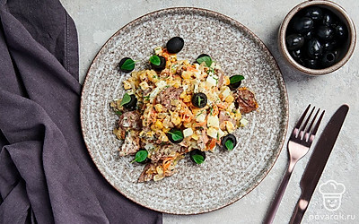 Перед подачей украсьте салат с кукурузой и куриной печенью половинками маслин.