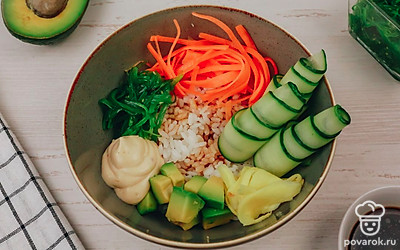 Выложите на рис по кругу нарезанные овощи, соус для поке, имбирь и салат чука.