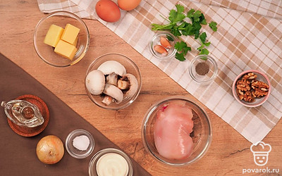 Вымойте и очистите шампиньоны, лук и чеснок. Чеснок пропустите через пресс. Лук мелко нашинкуйте вместе с шампиньонами Отварите яйца вкрутую. Приготовьте курицу. Филе отварите в подсоленной воде в течение 20 минут. Остудите его и измельчите. Грибы отварите в подсоленной воде 15 минут и порежьте на кусочки.