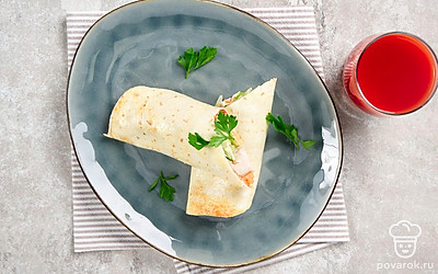 Разрежьте пополам и подайте тортилью с курицей на плоских тарелках со стаканом сока или любого другого холодного напитка. 