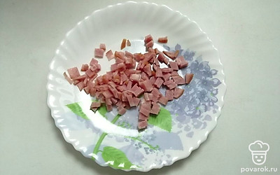 Копченую колбасу нарежьте маленькими кубиками.