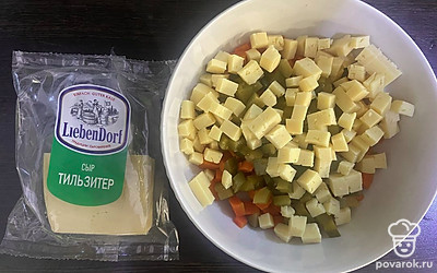 Сыр нарежьте кубиком и добавьте в салатник.