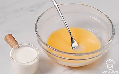 В широкую миску разбейте яйца, добавьте к ним молоко и слегка взбейте массу вилкой.