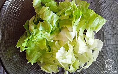 В салатницу выложите нарезанный салат айсберг.