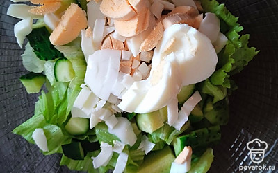 Огурец нашинкуйте кубиками. Яйца измельчите произвольно, тоже добавьте в салатницу.