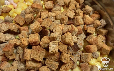 Всыпьте сухарики. Поскольку сухари соленые, салат не солите, если только не любите подсолить.