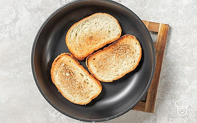 Выложите в сковороду ломтики хлеба. Обжарьте их с двух сторон до золотистой корочки. 