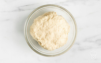 Порционно добавьте просеянную муку и замесите мягкое и гладкое тесто. Сформируйте из теста шар. Переложите в миску, накройте пленкой. Уберите в холодильник на 30-40 минут. 