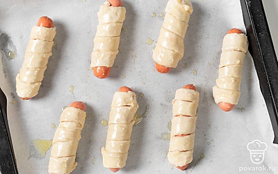 Растопите, а затем немного остудите сливочное масло. Смажьте им сосиски на противне.