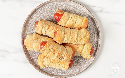 Переложите сосиски в тесте на тарелку и подавайте к столу. 