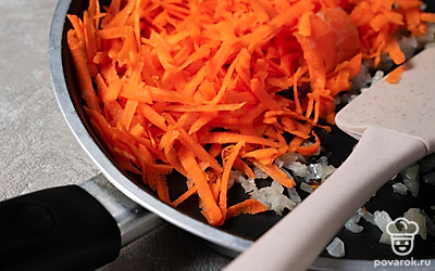 Натрите и выложите морковь в сковороду к луку. Перемешайте и готовьте зажарку еще 5-6 минут до мягкости, а после уберите сковороду с плиты. Добавьте к овощам соль и перец, а затем еще раз тщательно перемешайте ингредиенты.