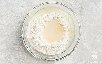 Добавьте в муку соленую воду и растительное масло. Хорошо перемешайте ингредиенты.