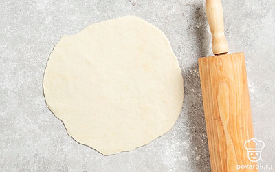 Возьмите одну порцию и с помощью скалки раскатайте ее в тонкую лепешку. Повторите это со всеми заготовками.