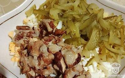 Соленые огурцы нарезать соломкой. Выложить в салатник обжаренные грибы. Заправить майонезом. Посолить, поперчить и все тщательно перемешать. 