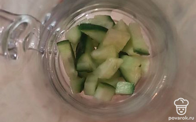 Нарезать огурцы, выложить на дно стакана. 
