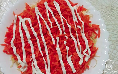 Третий слой — корейская морковка. Ее нарезаем и также смазываем майонезом.