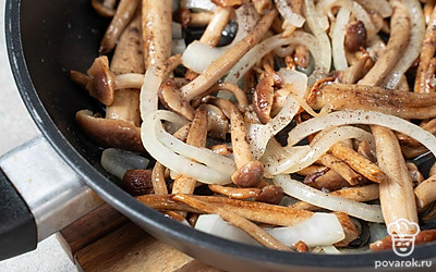 Добавьте к опятам соль и перец. Прожарьте еще около 3 минут, пока грибы слегка не подсушатся и не подрумянятся.