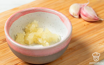 Чеснок измельчите на терке или пропустите через специальный пресс, а затем выложите в пиалу. 