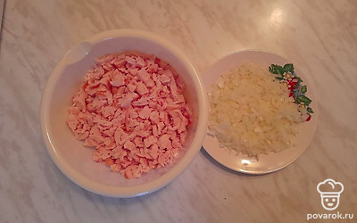 Удалите кости с куриной грудки, нарежьте ее средним кубиком. Очистите лук от шелухи и мелко накрошите овощ.
