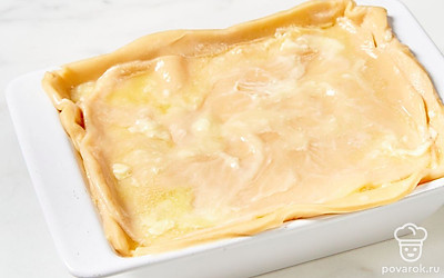 Последний пласт теста полейте оставшимся растопленным сливочным маслом. Отправьте пирог в духовку на 35 минут.