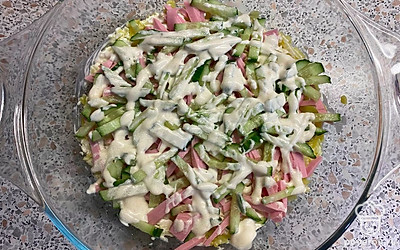 Огурец нарежем соломкой, выложим сверху на колбасу. Немного посолим и смажем майонезом.