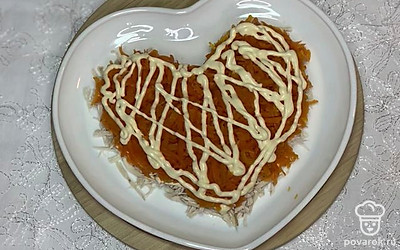 Сверху делаем сетку майонеза и выкладываем тёртую отварную морковь, затем снова майонез и солим.