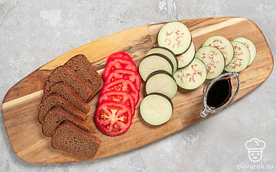 Нарежьте хлеб на кусочки, если это необходимо. Нарежьте баклажаны и помидоры кружочками. Сделайте на баклажанах надрез и сбрызните каждый ломтик соевым соусом. Дайте пропитаться в течение 5 минут.