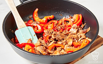 Болгарский перец нарежьте некрупными ломтиками и добавьте в сковороду. Перемешайте, готовьте начинку еще 2-3 минуты.