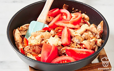 Помидор нарежьте дольками. Чеснок мелко порубите или натрите на терке. Добавьте овощи в сковороду, хорошо перемешайте.