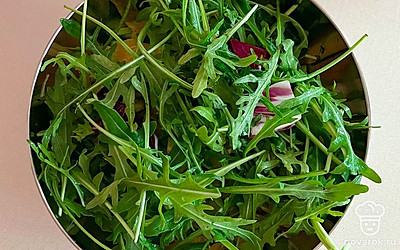 Выложите нарезанный кусочками апельсин и руколу.